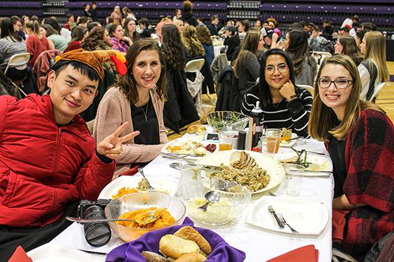图为参加波胆网站丰收晚宴的国际学生, 吃饭时对着镜头微笑