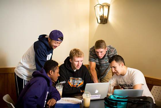 图为一群波胆网站的男学生围着几台笔记本电脑一起工作