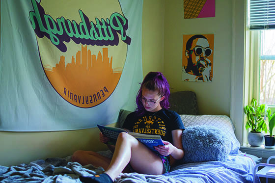 图为英国波胆网站的一名女学生坐在宿舍的床上读书