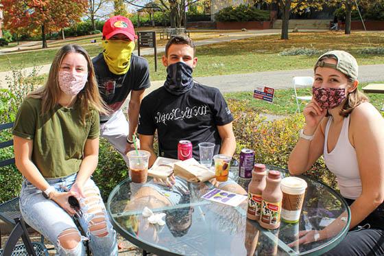 四名波胆网站的学生戴着口罩，在足球波胆平台外面一起闲逛